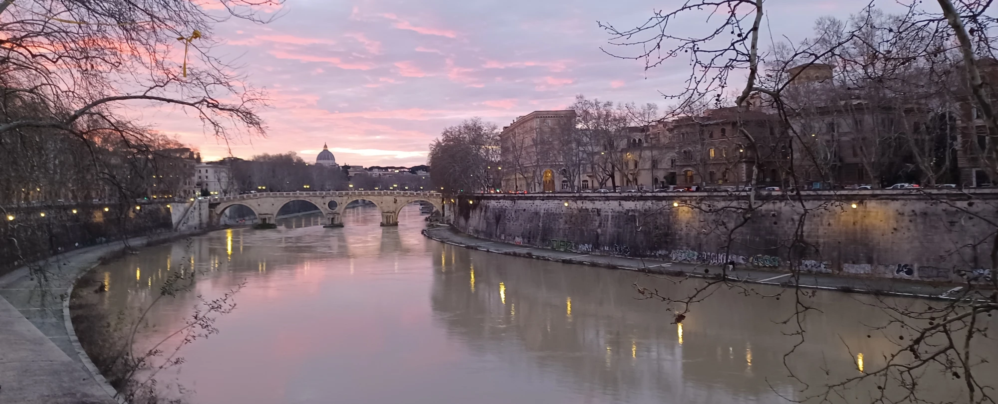 Atardecer sobre el río Tíber, el Ponte Sisto y la cúpula de San Pedro vistos desde el puente Garibaldi.